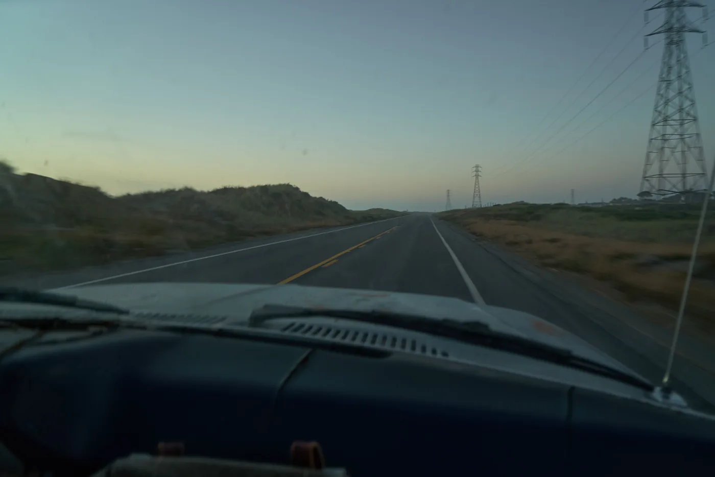 A car on the open road at dusk, protected by comprehensive motor cover
